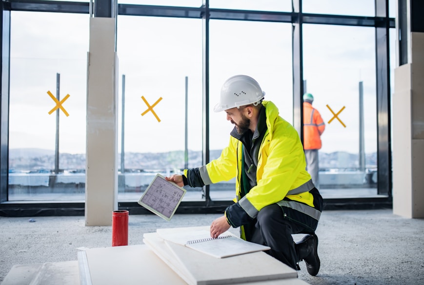 Safety professional in hard hat and high-visibility vest at construction site