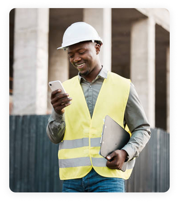 Safety professional in PPE checking mobile device at construction site